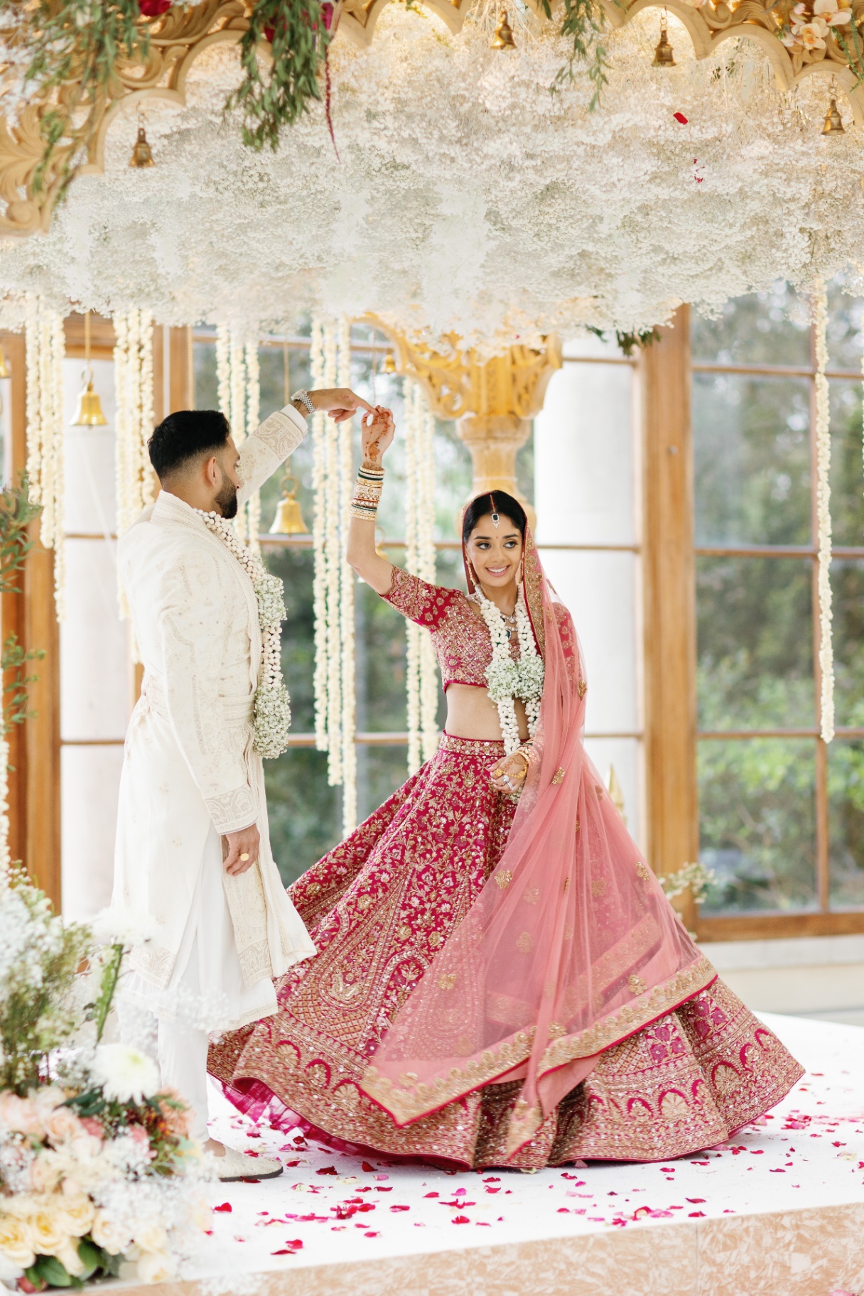 Bride and groom under floral mandap